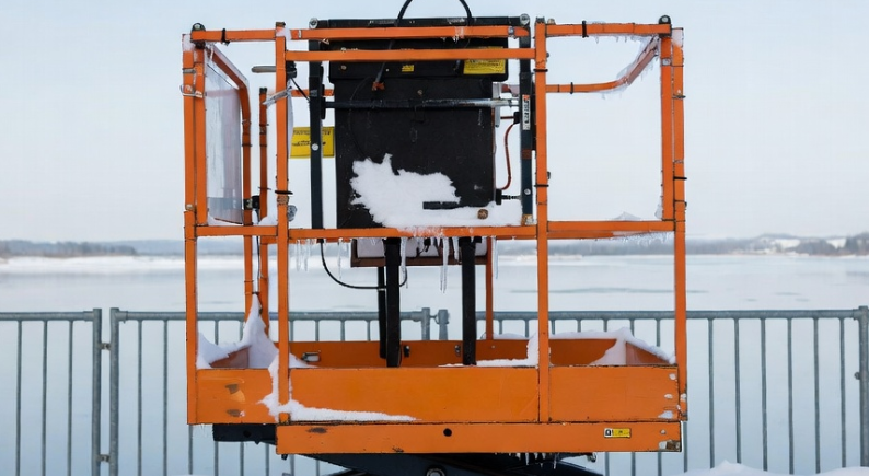 Scissor lift operating in freezing cold weather highlighting lead-acid battery capacity loss, hydraulic fluid thickening, and fleet project delays at 0°F Scissor lift operating in freezing cold weather highlighting lead-acid battery capacity loss, hydraulic fluid thickening, and fleet project delays at 0°F